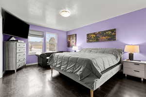 Bedroom with dark wood-style floors and a textured ceiling