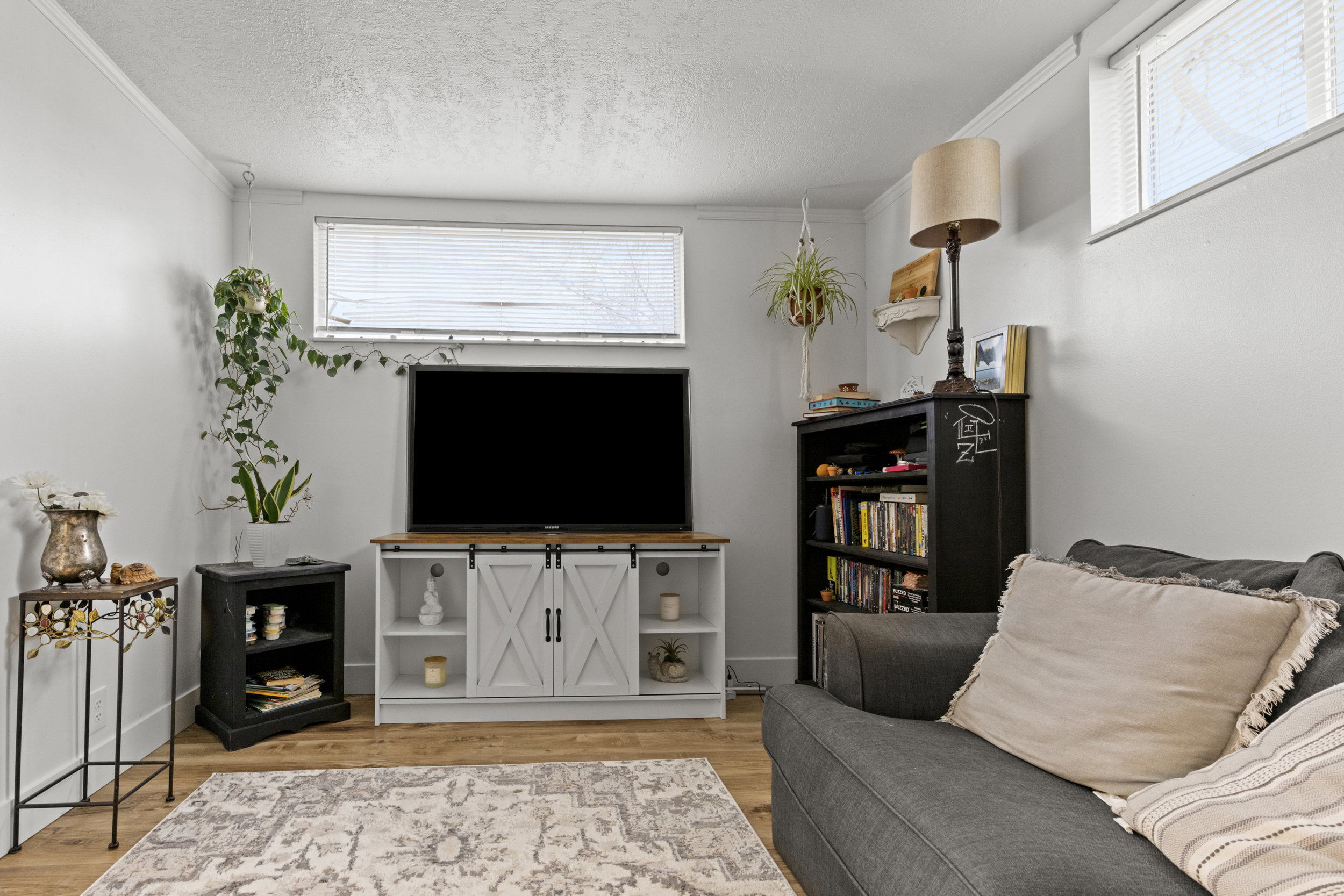 Living area featuring light wood finished floors, ornamental molding, and a textured ceiling