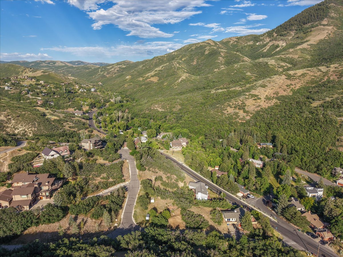 Expansive mountain setting featuring lush green hillsides and scattered residential properties