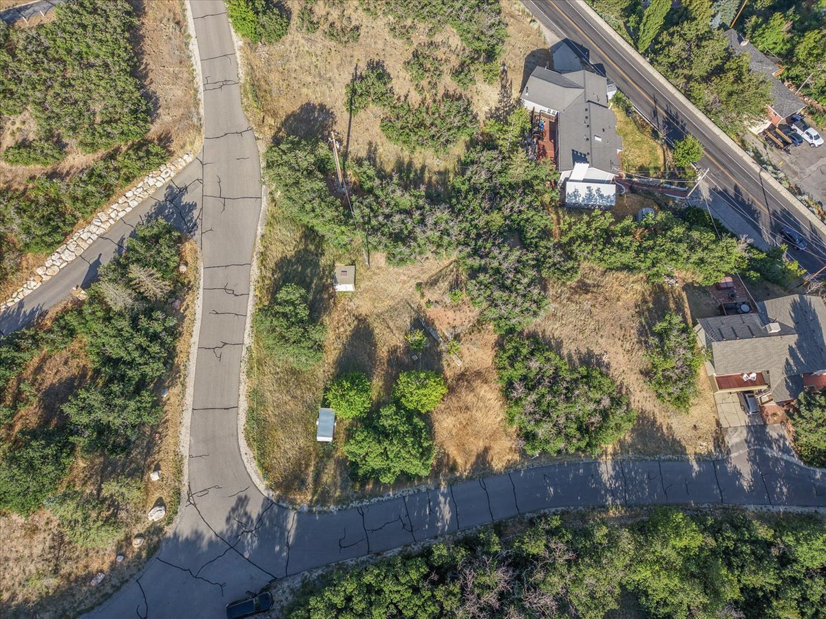 Aerial perspective featuring varied topography, established vegetation, and paved road access