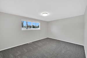 Spare room with carpet and baseboards