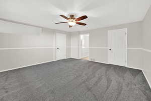 Unfurnished bedroom featuring connected bathroom, carpet floors, ceiling fan, and a closet