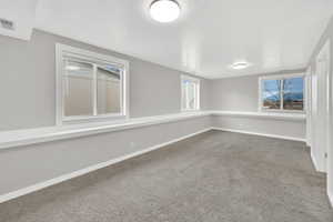 Empty room featuring baseboards and light carpet