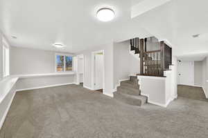 Below grade area featuring stairs and carpet flooring