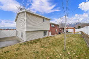 Rear view of house with a gazebo, a fenced backyard, and a gate