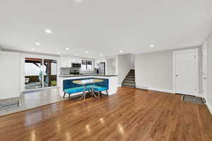 Kitchen with white cabinets, open floor plan, dark countertops, recessed lighting, and stainless steel appliances