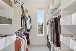 Generous Walk in closet with light colored carpet