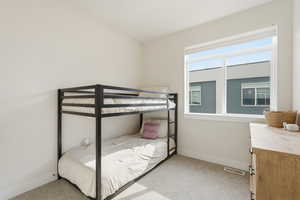 Bedroom with light colored carpet and baseboards