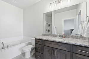 Bathroom with a bath, vanity, and a shower