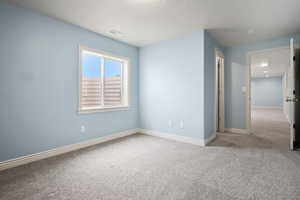 Unfurnished bedroom featuring carpet flooring and a textured ceiling