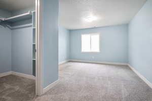 Empty room with a textured ceiling and carpet