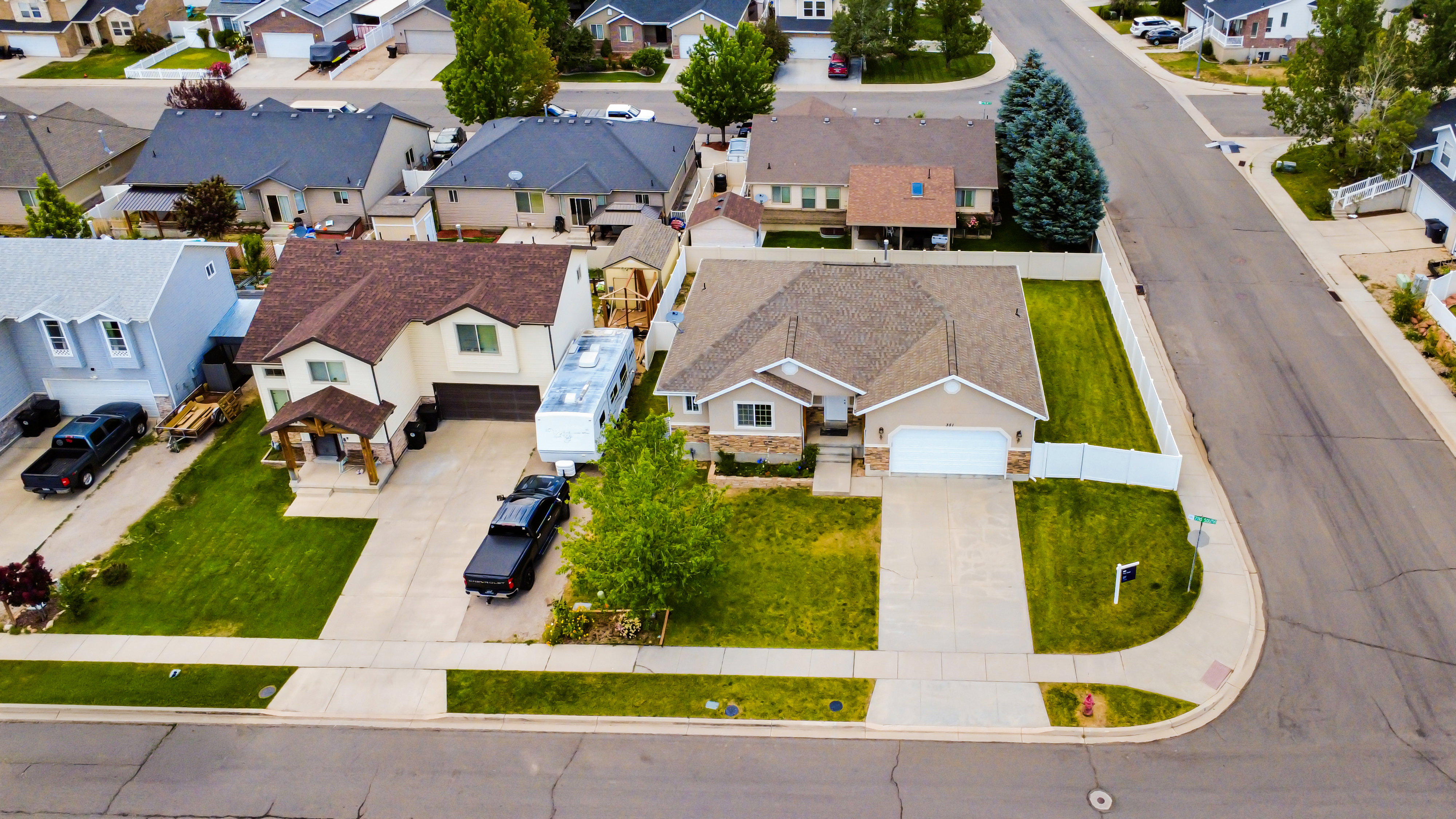 Two-story residence with a brown shingle roof and light-toned siding
