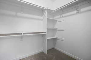 Walk in closet featuring dark carpet