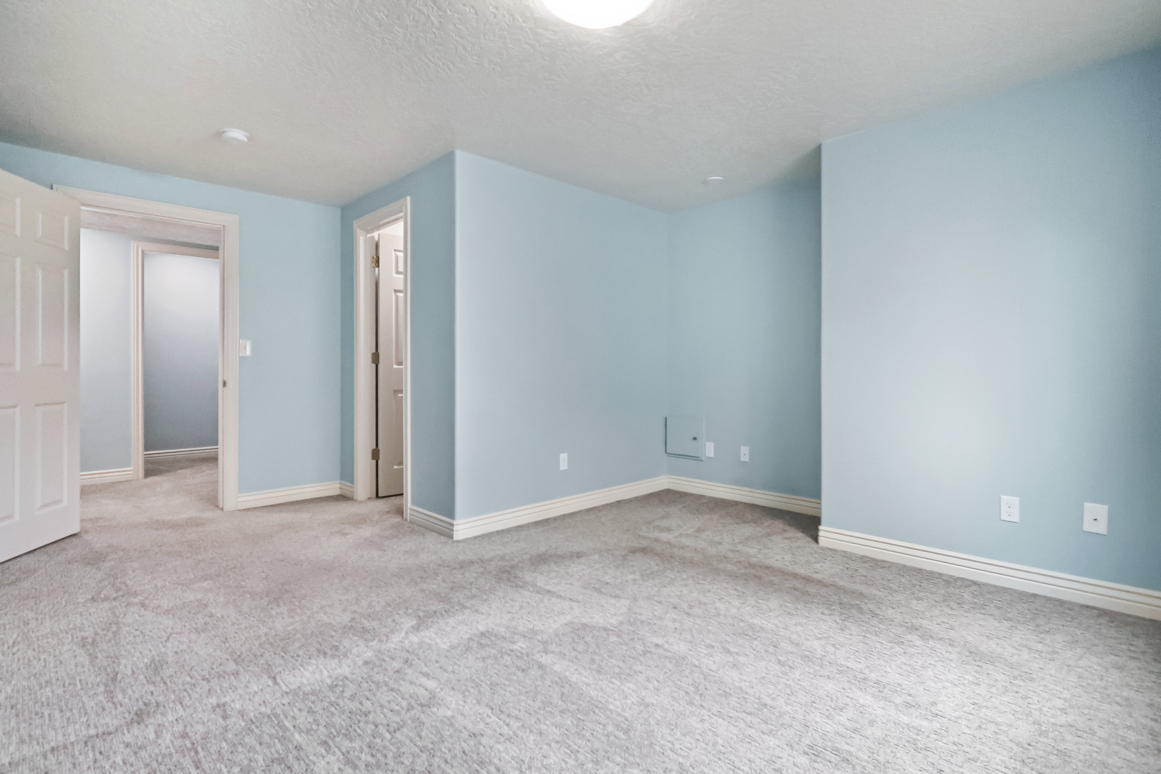 Carpeted spare room with a textured ceiling and baseboards