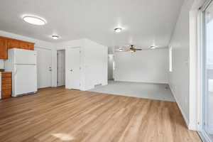 Unfurnished living room with a ceiling fan and light wood-style flooring