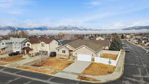 View of front of home featuring a residential view, driveway, stone siding, and a mountain view