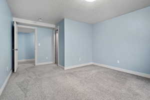 Unfurnished bedroom featuring carpet and a textured ceiling