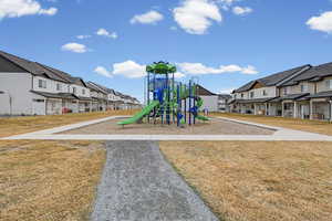 Communal playground featuring a residential view and a lawn