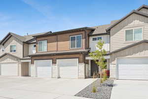Craftsman-style home with board and batten siding, a shingled roof, driveway, stone siding, and a garage