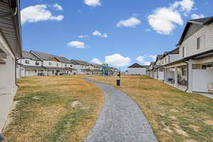 View of grassy yard featuring a playground and a residential view