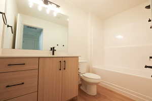 Bathroom featuring vanity, light wood finished floors, and  shower combination