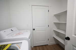 Laundry area featuring dark wood-style flooring and washer and clothes dryer