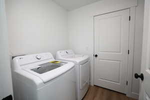 Laundry area featuring dark wood finished floors and washing machine and dryer