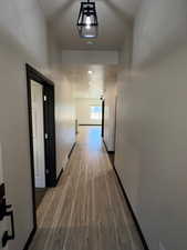 Corridor featuring light wood-type flooring and baseboards