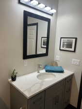 Modern vanity featuring a light-toned countertop with veining, an undermount sink, and a brushed nickel faucet