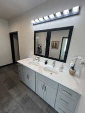Dual vanity with a white countertop and undermount sinks, light gray cabinetry, and brushed nickel hardware