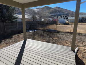 Deck featuring a shed, a fenced backyard, and a mountain view