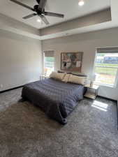 Spacious room featuring a tray ceiling with recessed lighting and a ceiling fan