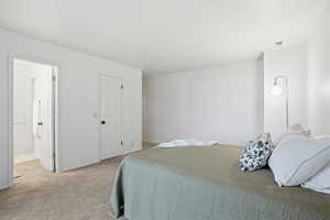 Bedroom with light colored carpet and baseboards