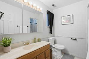 Full bath with vanity, curtained shower, and light tile patterned floors