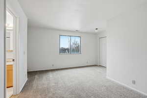 Spare room with light carpet and baseboards