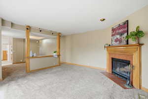 Unfurnished living room with carpet floors and a tile fireplace