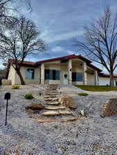 View of front of house featuring stucco siding and a tiled roof