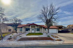 Single story home with concrete driveway, stucco siding, an attached garage, and a tiled roof