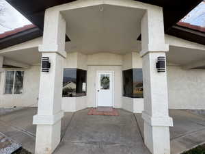 Entrance to property featuring stucco siding and a porch