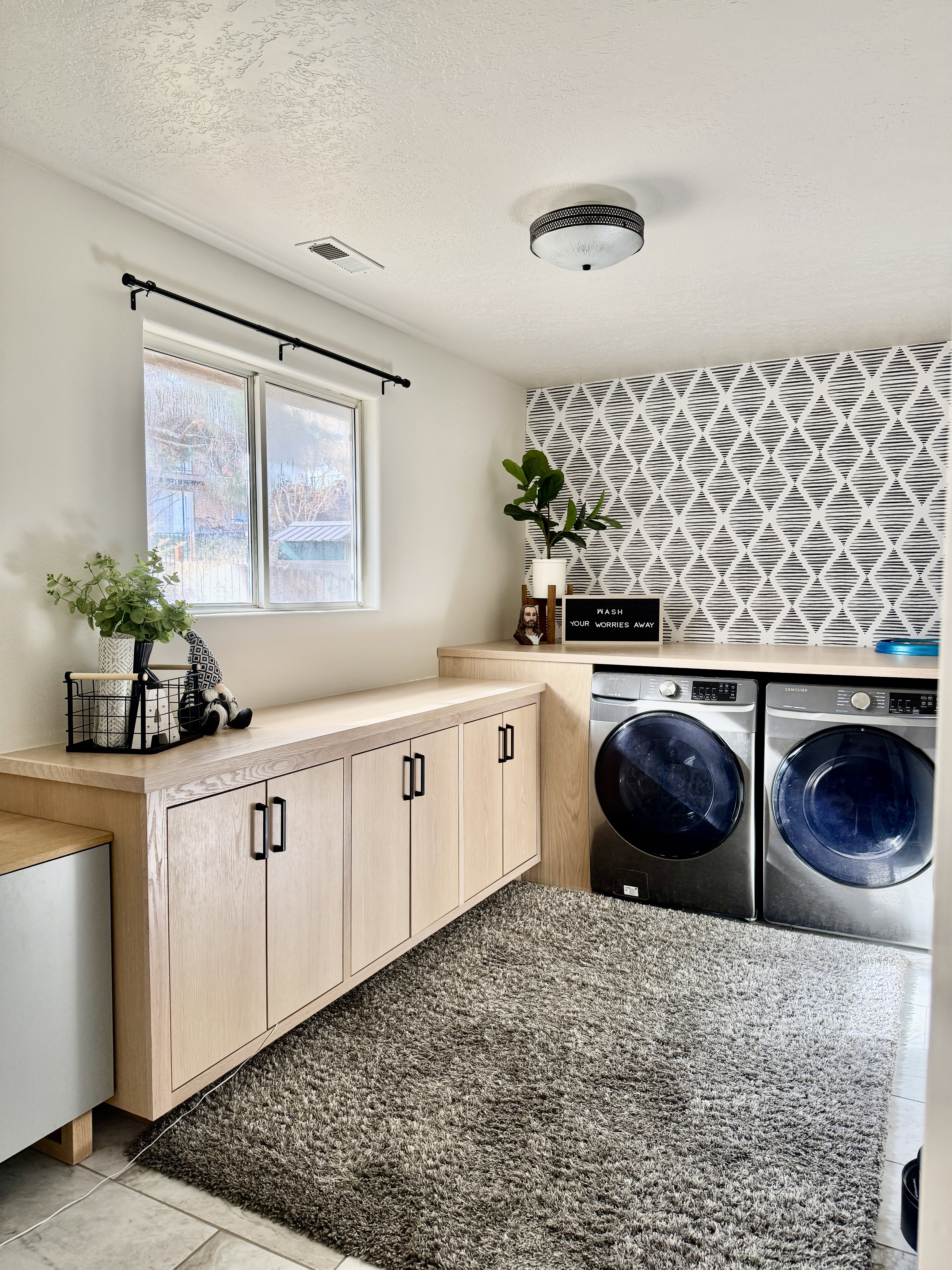 Laundry area with washer and clothes dryer, cabinet space, and a textured ceiling