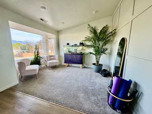 Living area featuring a textured ceiling and wood finished accent wall