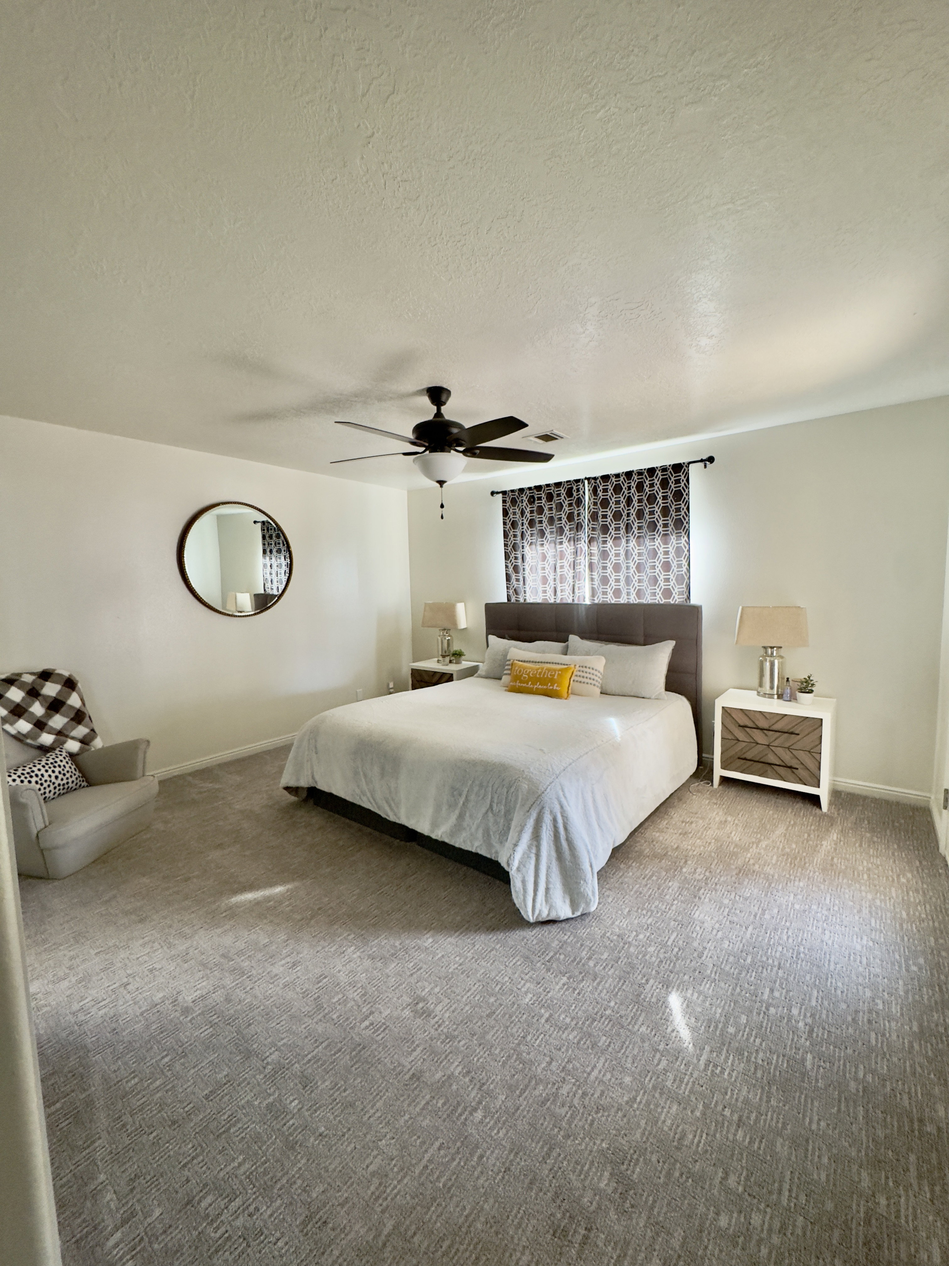 Bedroom with carpet floors, a textured ceiling, and ceiling fan