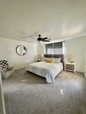 Bedroom with carpet floors, a textured ceiling, and ceiling fan