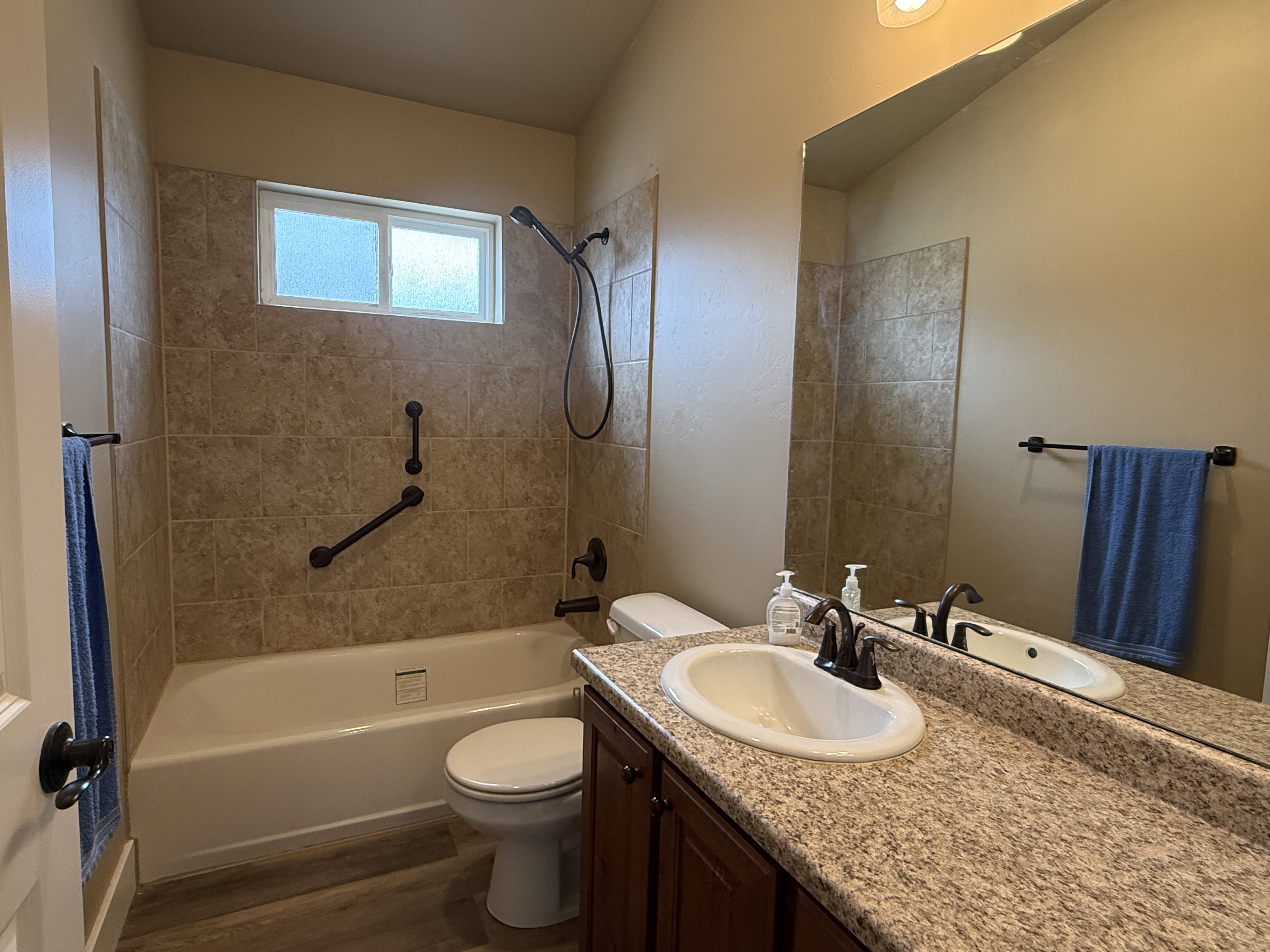 Full bath with vanity, washtub / shower combination, and dark wood finished floors