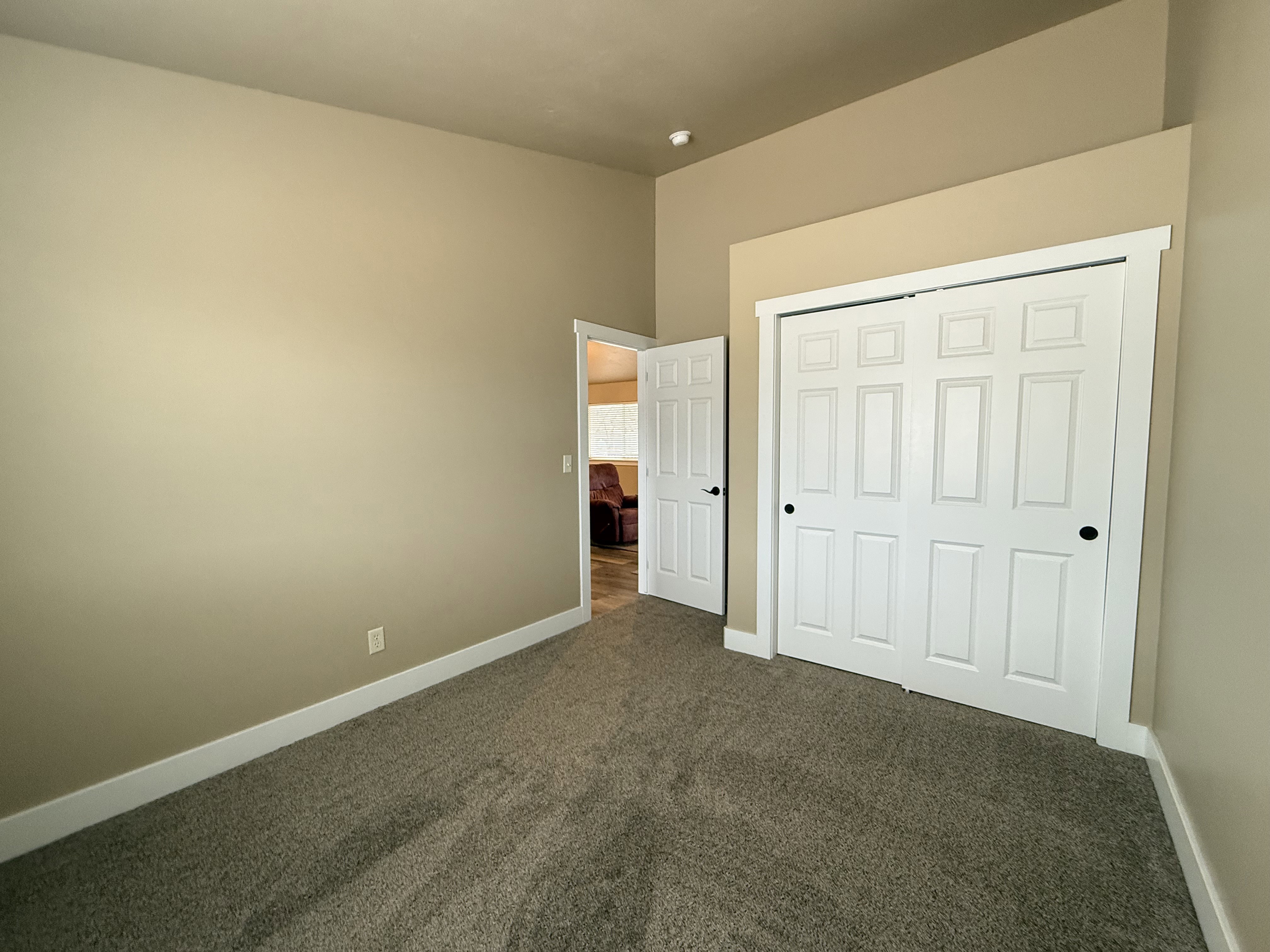 Unfurnished bedroom with dark colored carpet and a closet