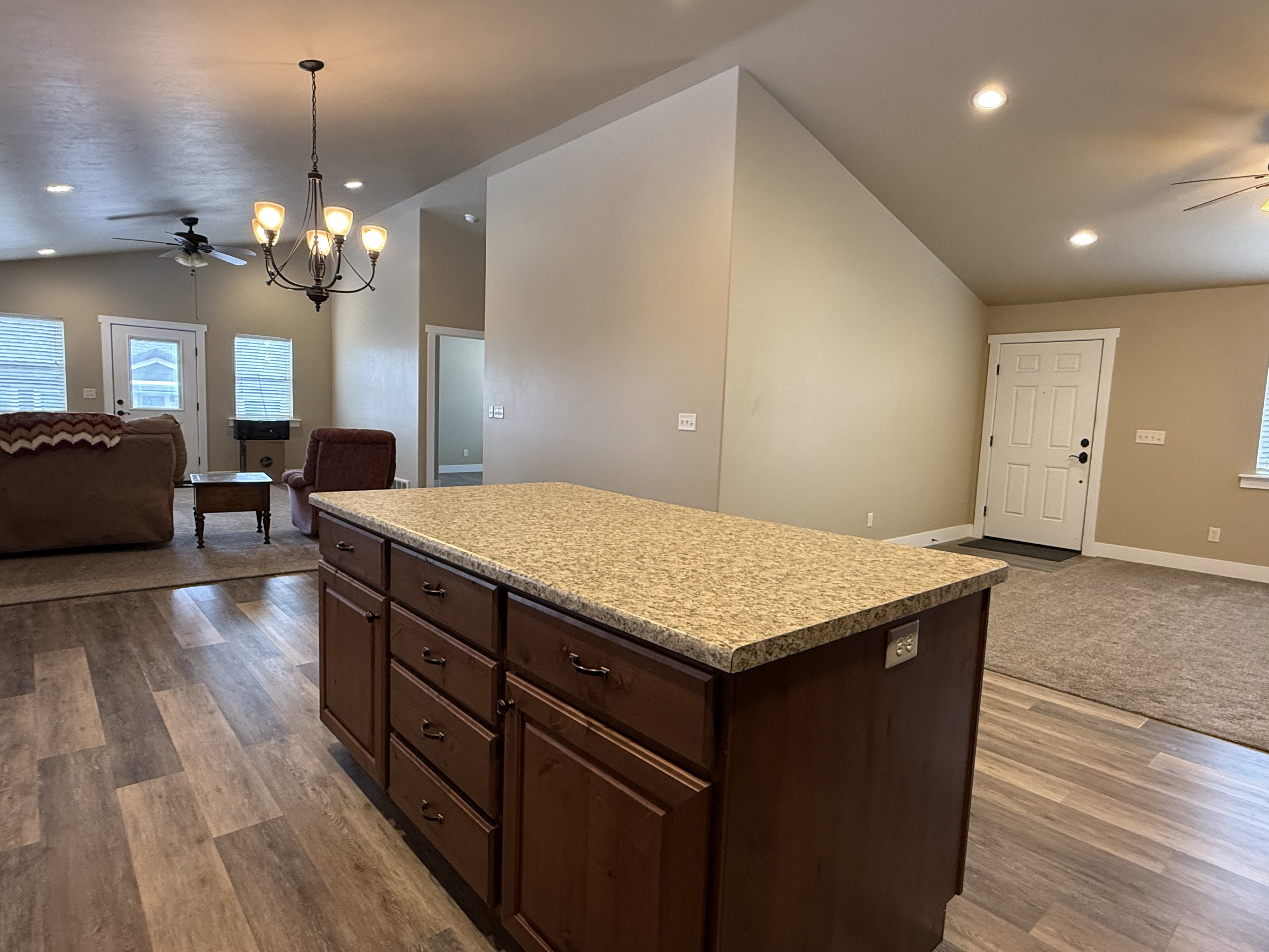 Kitchen with open floor plan, ceiling fan, lofted ceiling, and dark wood finish cabinetry