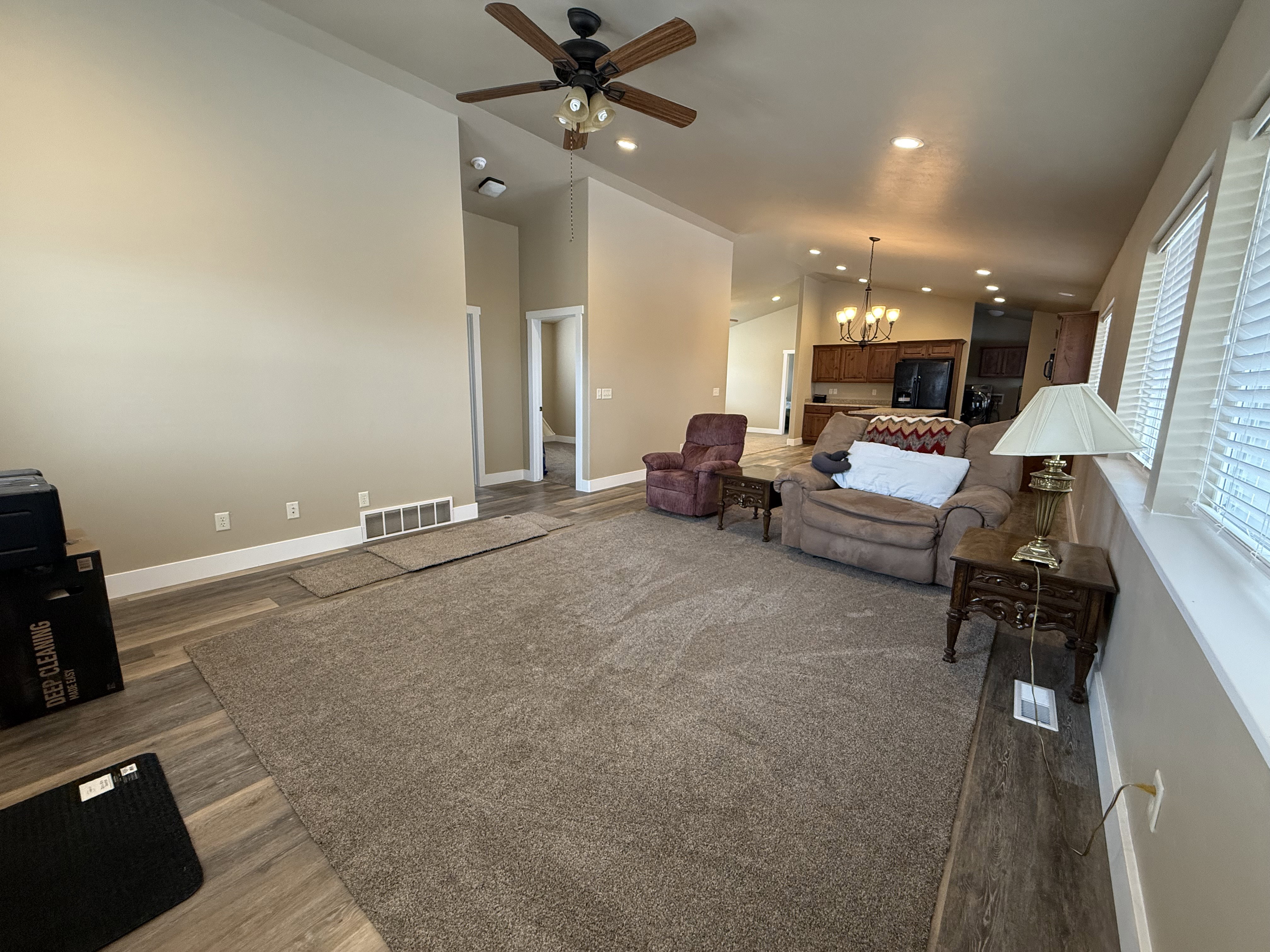 Living room featuring hanging lights, ceiling fan, dark wood finished floors, and vaulted ceiling