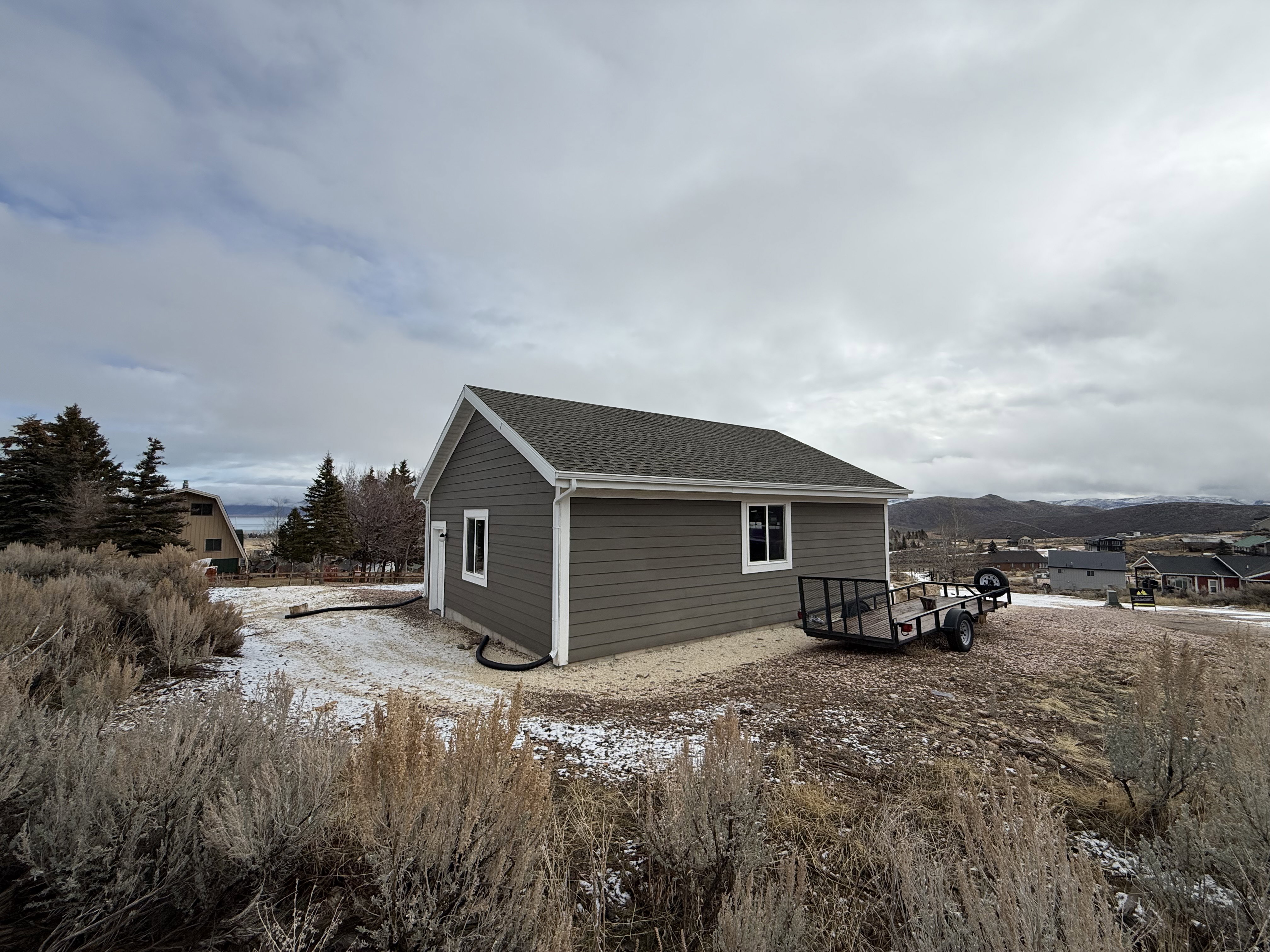 View of home's exterior with roof with shingles and a deck with mountain view