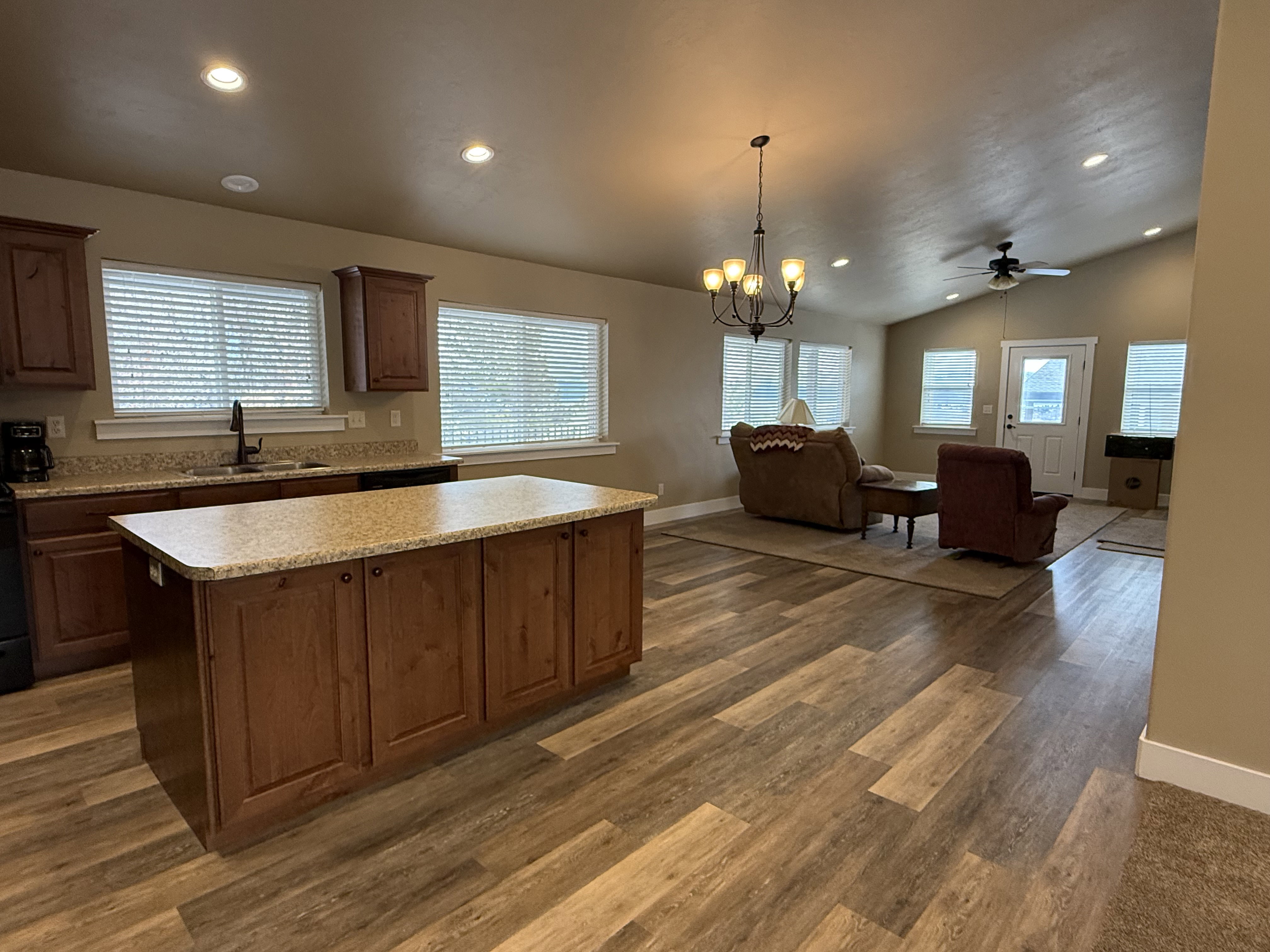 Kitchen featuring hanging lights, light countertops, a center island, open floor plan, and lofted ceiling