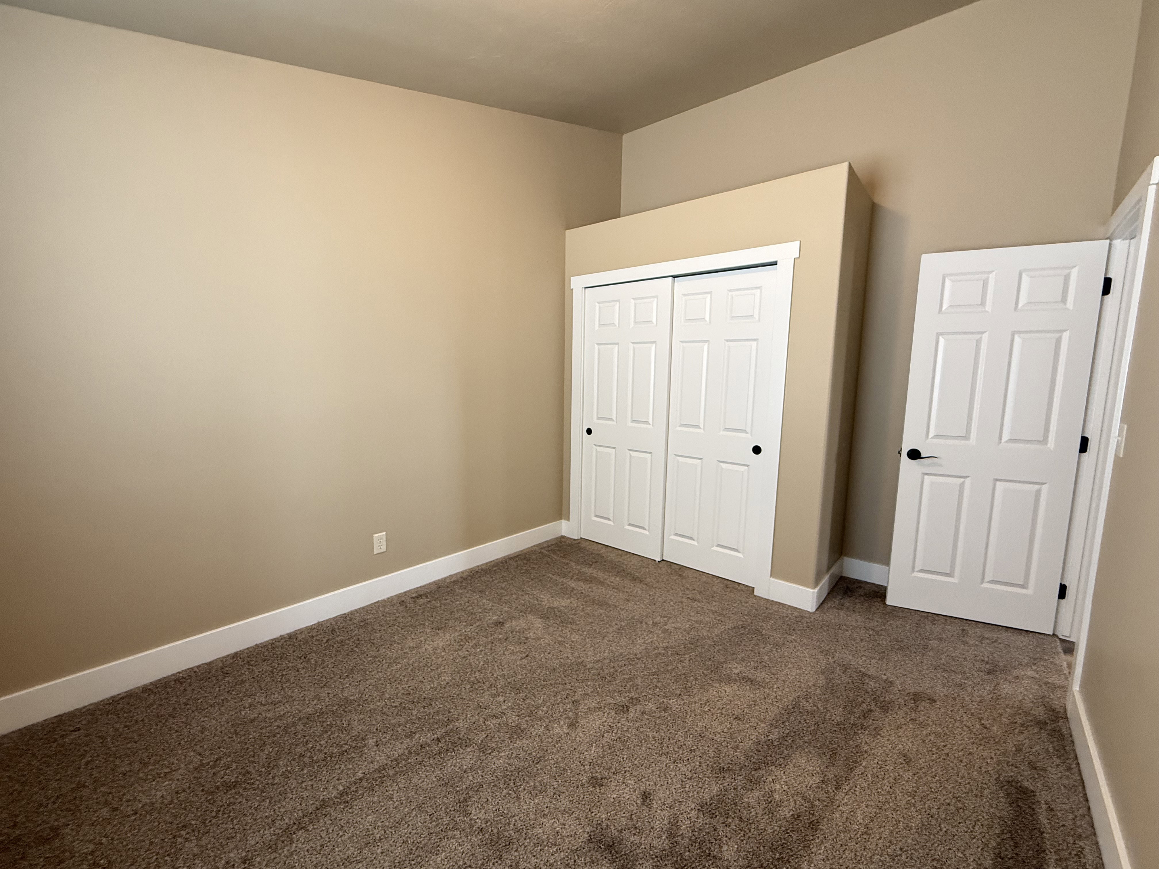 Unfurnished bedroom with dark carpet and a closet